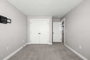 Unfurnished bedroom featuring carpet and a closet
