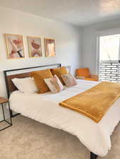 Bedroom featuring light carpet and a textured ceiling