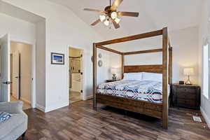 Bedroom featuring dark wood-style floors, vaulted ceiling, ceiling fan, and ensuite bathroom