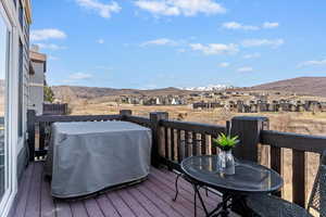 Wooden terrace with area for grilling, a mountain view, a residential view, and outdoor dining area