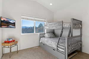 Bedroom featuring light colored carpet, lofted ceiling, and recessed lighting