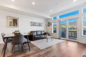 Living area with wood finished floors, a mountain view, recessed lighting, and crown molding