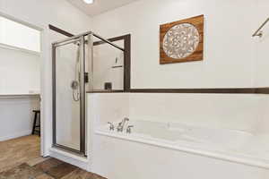 Bathroom featuring a shower stall, a bath, and a spacious closet