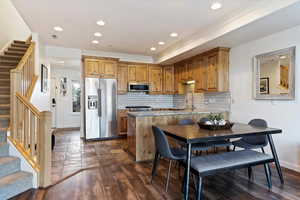 Kitchen with stainless steel appliances, a peninsula, dark wood-type flooring, recessed lighting, and wood finish cabinets