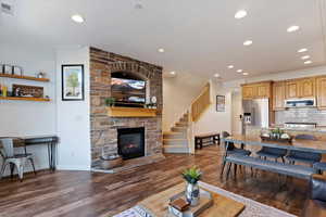 Living area with a fireplace, dark wood-style floors, ornamental molding, and recessed lighting