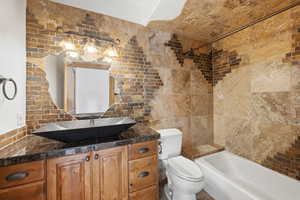 Bathroom featuring tile walls, vanity, and shower / bathtub combination