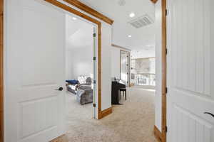 Hall with light colored carpet and recessed lighting