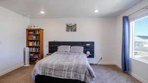 Carpeted bedroom with recessed lighting