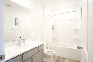 Bathroom featuring vanity, light wood-style floors, and shower / bathtub combination with curtain
