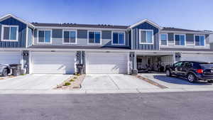 Traditional home with board and batten siding, an attached garage, and concrete driveway