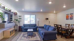 Living area featuring light wood-style flooring, recessed lighting, and a textured ceiling