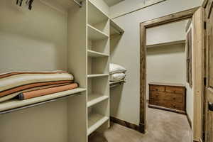 Walk in closet featuring light colored carpet
