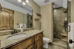 Full bathroom with vanity, a stall shower, and light tile patterned floors