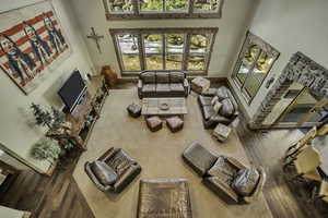 Living room featuring a high ceiling and wood-type flooring