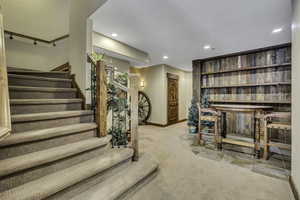 Living area with recessed lighting and light carpet