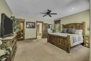 Bedroom featuring light colored carpet, ensuite bathroom, a ceiling fan, and recessed lighting
