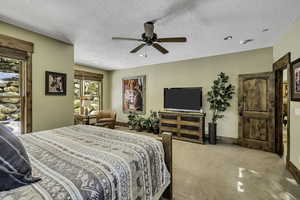 Bedroom with light colored carpet, ceiling fan, a textured ceiling, and recessed lighting