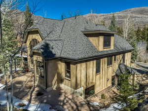 View of side of home with roof with shingles