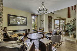 Living room featuring a textured ceiling, hardwood / wood-style flooring, and suspended lighting