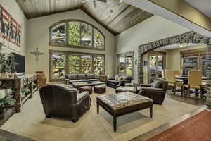 Living area featuring a high wood ceiling, wood finished floors, a ceiling fan, and arched walkways