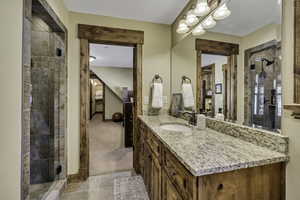 Full bath with a shower stall, vanity, and light colored carpet