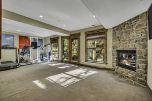 Workout room featuring carpet flooring, a fireplace, and recessed lighting