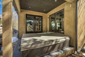 Deck featuring a hot tub and french doors