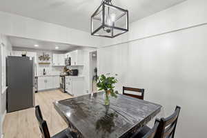 Dining room featuring light wood-style flooring and hanging lights