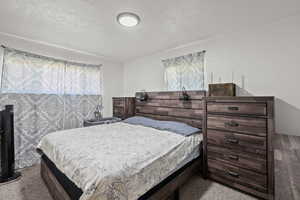 Bedroom featuring a textured ceiling and carpet flooring