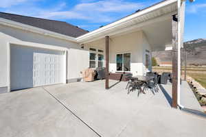 View of patio / terrace with outdoor dining space, an attached garage, a grill, and concrete driveway