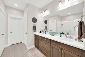 Bathroom featuring double vanity, a stall shower, recessed lighting, and light tile patterned floors