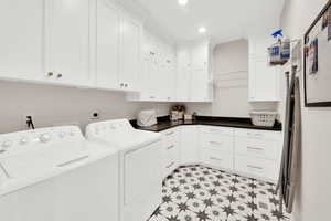 Laundry area featuring recessed lighting, cabinet space, washer and dryer, and light flooring