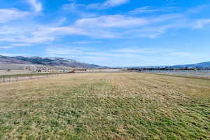 View of yard with a rural view and a mountain view