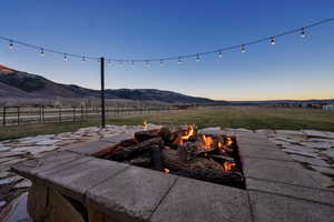 Patio terrace at dusk featuring a mountain view, a patio, and a fire pit