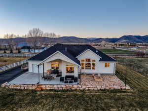 Rear view of house featuring a fenced backyard, a patio area, a garage, and a mountain view