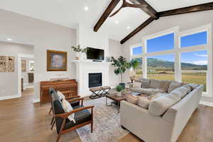 Living area featuring light wood-type flooring, a large fireplace, ceiling fan, recessed lighting, and vaulted ceiling