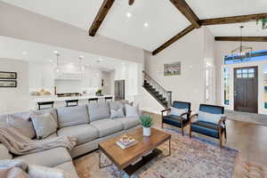 Living room featuring light wood-style flooring, lofted ceiling, and hanging lights