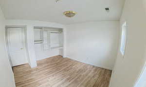 Unfurnished bedroom featuring light wood finished floors and a closet