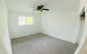 Unfurnished bedroom featuring carpet, a closet, and a ceiling fan