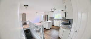 Kitchen featuring light countertops, dark wood finished floors, white cabinets, and stainless steel appliances