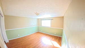 Unfurnished room with light wood-type flooring and a textured ceiling