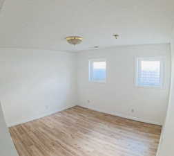 Unfurnished room with light wood finished floors and baseboards