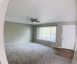 Foyer entrance with carpet flooring and a ceiling fan