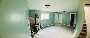 Workout area featuring a textured ceiling, a wood stove, and light colored carpet