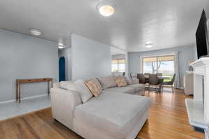 Living room with arched walkways, light wood finished floors, and a fireplace