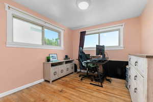 Office area with light wood-style flooring and plenty of natural light