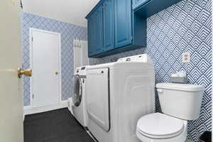 Laundry area featuring tile patterned floors, independent washer and dryer, and wallpapered walls