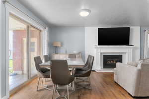 Dining area featuring light wood-style floors and a brick fireplace
