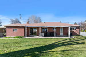 Back of house with brick siding, a chimney, and a shingled roof
