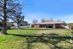 Back of house with a patio, brick siding, and a chimney